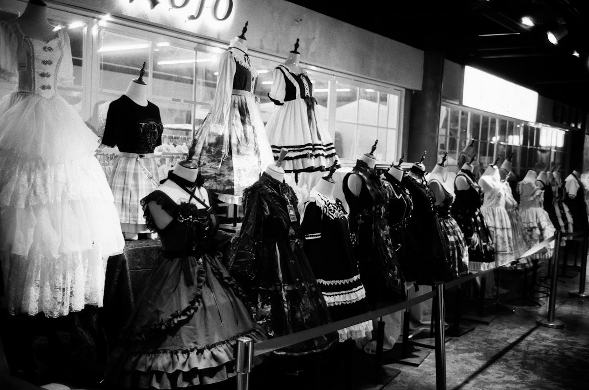 a black and white photo of dresses on display