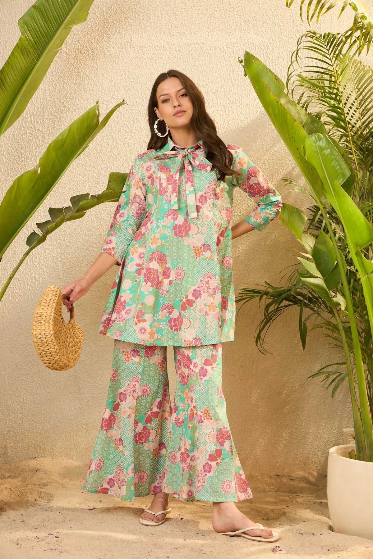 Woman in floral print outfit with straw bag