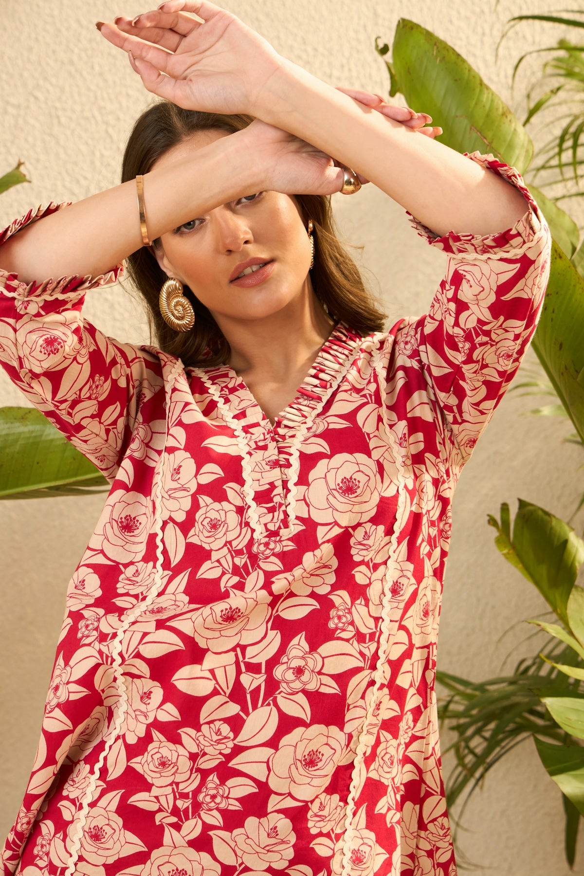 Woman in a red floral dress with arms crossed